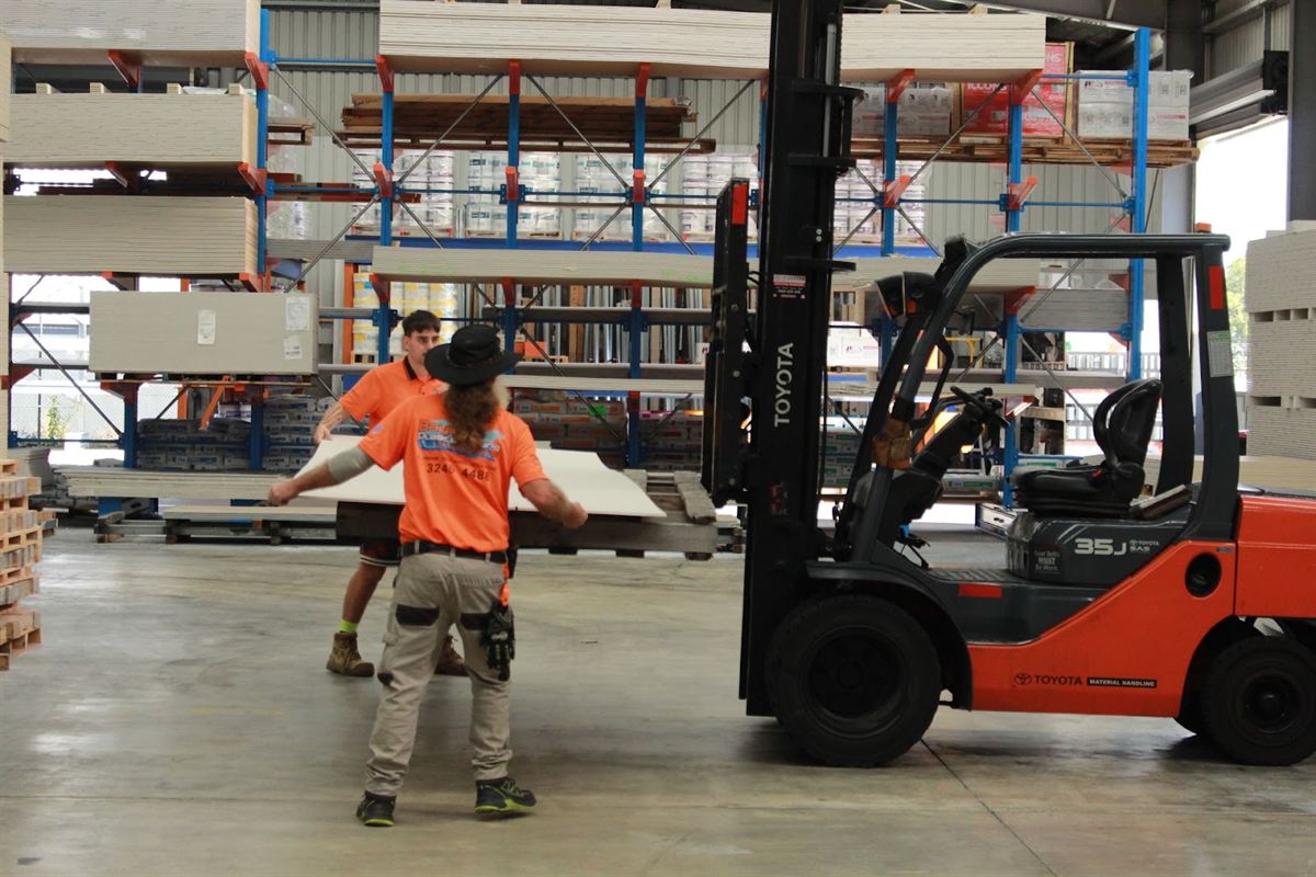 Bayside Plasterboard staff moving plasterboard sheets in the warehouse
