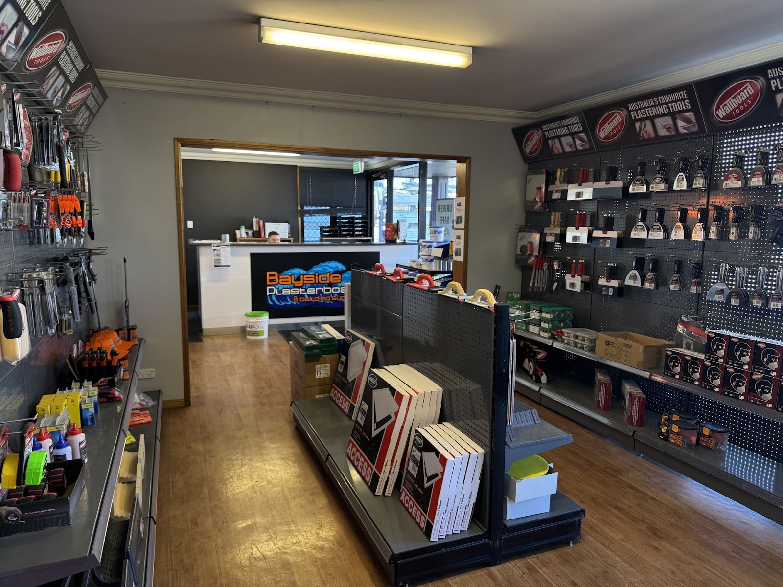 Northside showroom: pegboard walls of Wallboard Tools, a centre gondola of Access panel boxes and the sales counter with